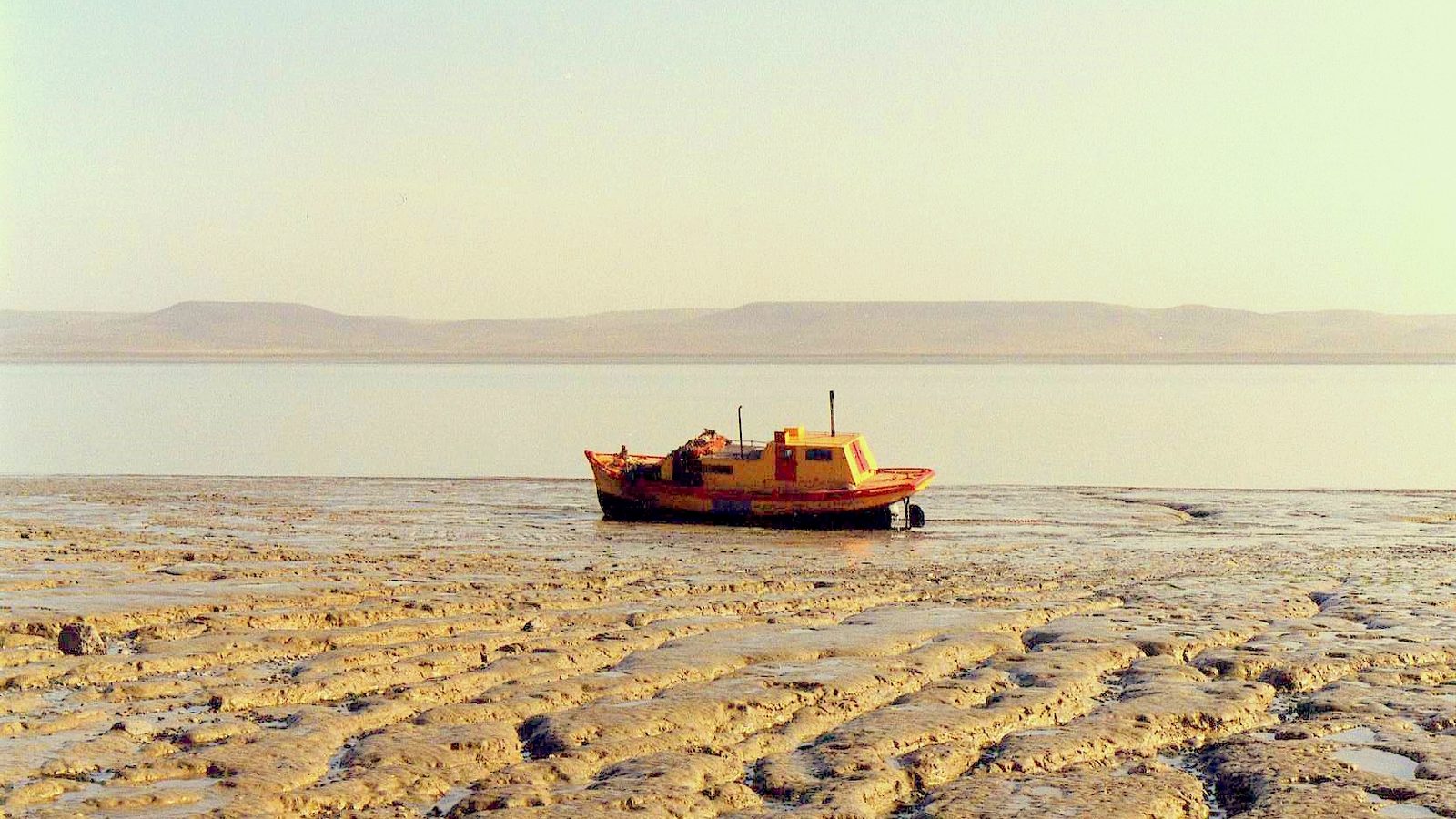 Barco encalhado na maré baixa no estuário do rio Gallegos